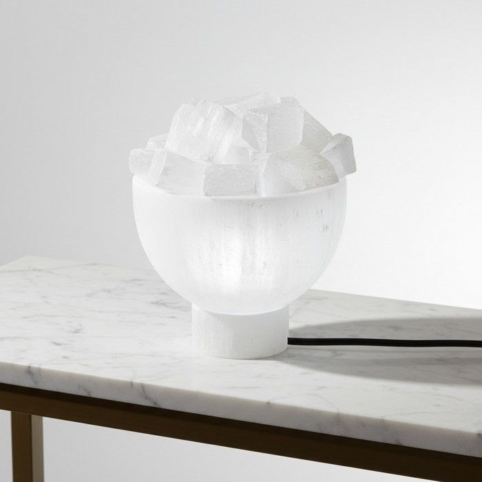 Kindred Crystal Collective — Selenite Bowl Lamp, white selenite bowl lamp filled with raw selenite chunks, illuminated with warm glow, white background