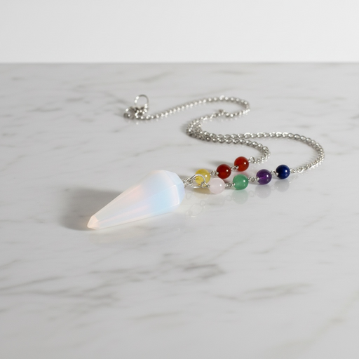Selenite Pendulum with Chakra Beads on white background — translucent white selenite with colourful chakra beads