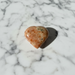 Sunstone crystal heart close-up showing warm orange tones and natural sparkle, a healing crystal for joy, confidence and life-force energy
