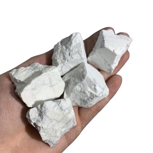 Kindred Crystal Collective — White Howlite Rough 1KG, white and grey veined raw howlite chunks spilling from a clear bag on white background.