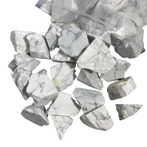 Kindred Crystal Collective — White Howlite Rough 1KG, white and grey veined raw howlite chunks spilling from a clear bag on white background.