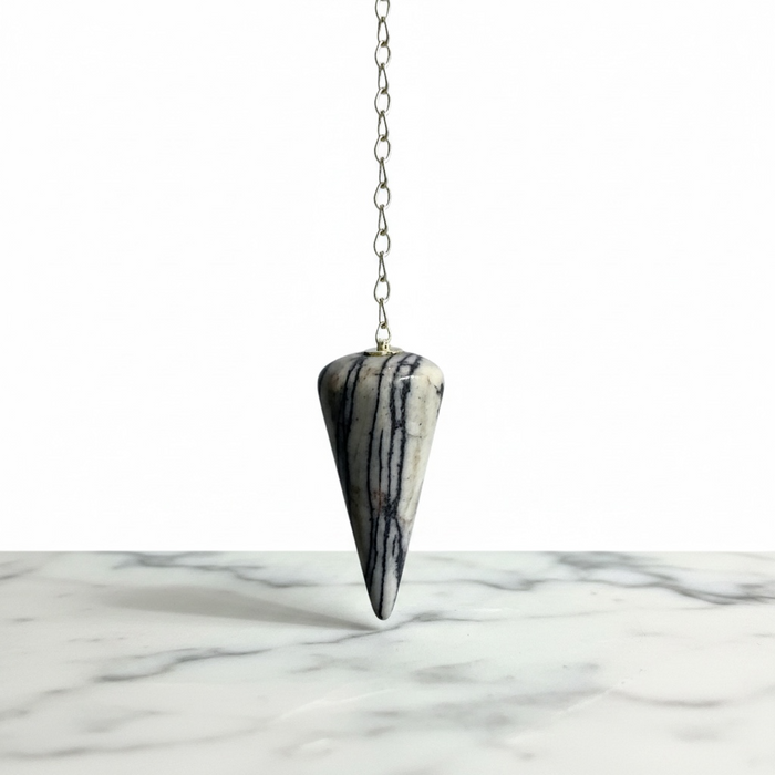 Zebra Jasper Pendulum crystal on white background  distinctive black and white striped pattern