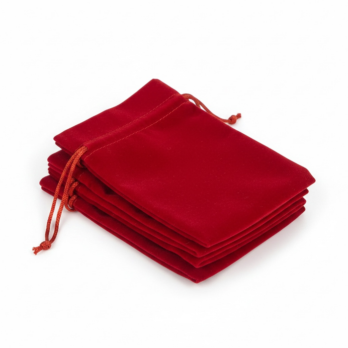 Stack of bright red velvet drawstring bags on a white background
