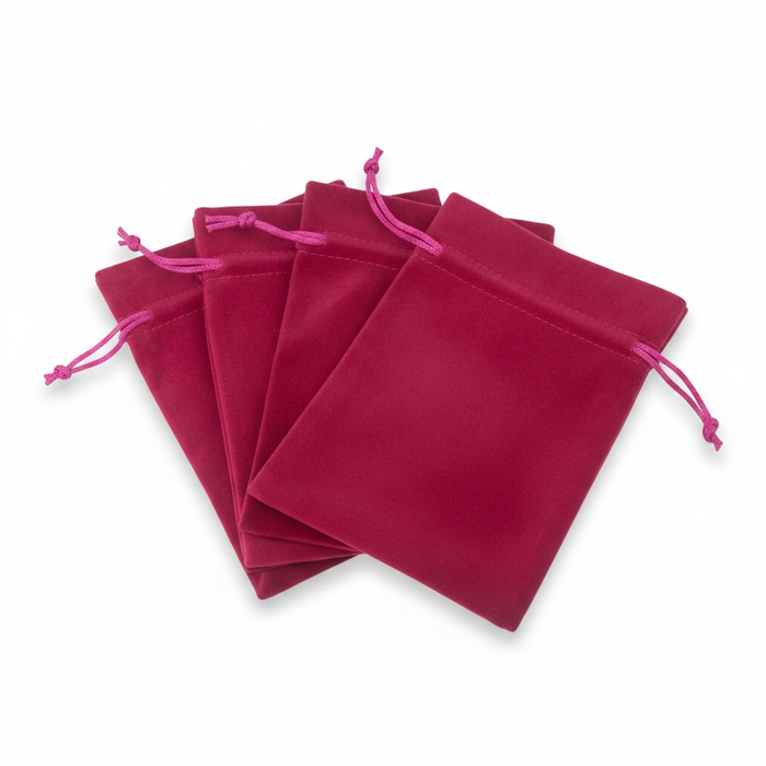 Set of pink velvet drawstring bags on a white background