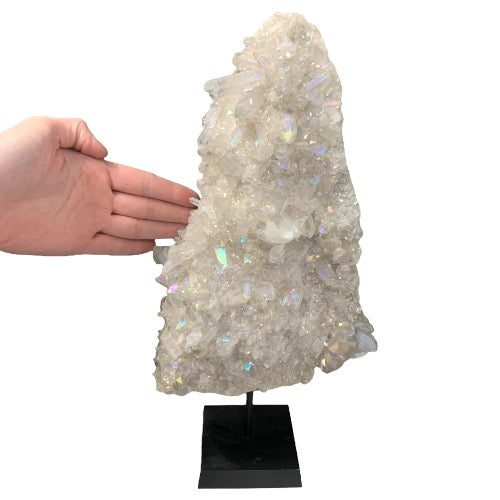 Kindred Crystal Collective — Angel Aura Quartz Cluster, size reference with hand showing scale of large angel aura cluster on black stand