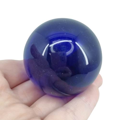 Kindred Crystal Collective — Dark Blue Obsidian Sphere, polished deep blue glass sphere, size reference with hand