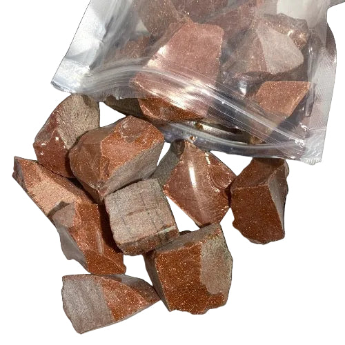 Kindred Crystal Collective — Goldstone Rough 1KG, glittering orange-gold raw goldstone chunks spilling from a clear bag on white background.