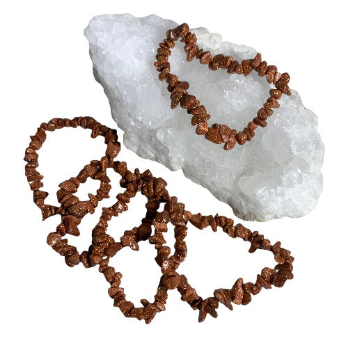 Kindred Crystal Collective — Goldstone Chip Bracelet (Pack of 5), copper-brown sparkling chip bracelets arranged around a white crystal cluster.