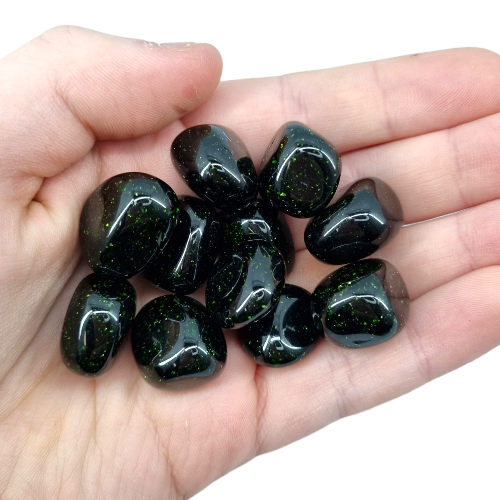 Kindred Crystal Collective — Green Goldstone Tumbled 1.5–2cm, ten deep green goldstone glass pieces with metallic sparkle held in open palm