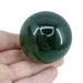 Kindred Crystal Collective — Green Obsidian Sphere, polished deep forest green glass sphere, size reference with hand