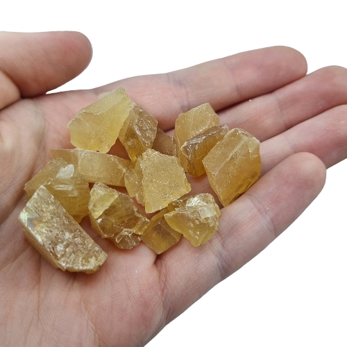 Kindred Crystal Collective — Honey Calcite Rough 500g, warm golden-amber raw honey calcite pieces in a clear bag on white background