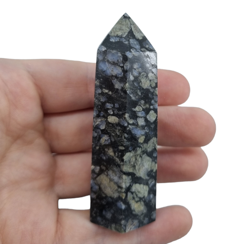 Kindred Crystal Collective — Llanite Generator Grey Matrix, hand-held polished Llanite Que Sera crystal tower showing dark grey matrix and speckled blue-grey patterning, size reference