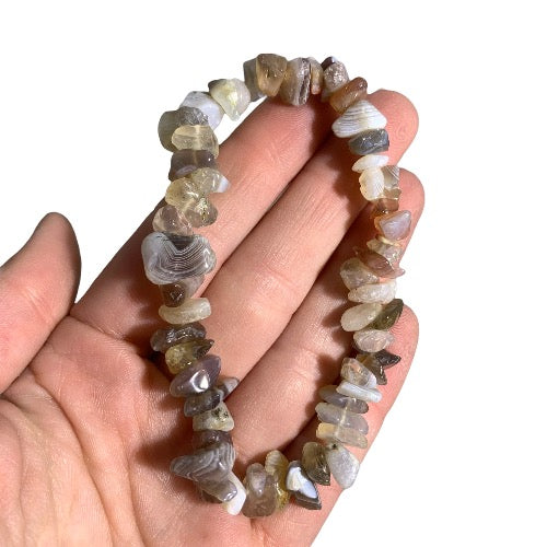 Kindred Crystal Collective — Natural Agate Chip Bracelet (Pack of 5), grey, cream and brown chip bracelets arranged around a white crystal cluster on a white background.