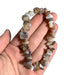 Kindred Crystal Collective — Natural Agate Chip Bracelet (Pack of 5), grey, cream and brown chip bracelets arranged around a white crystal cluster on a white background.
