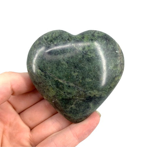 Nephrite jade heart close-up showing rich green tones and smooth waxy lustre, a timeless auspicious crystal for feng shui, protection and prosperity