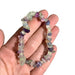 Kindred Crystal Collective — Rainbow Fluorite Chip Bracelets (Pack of 5), five green, purple and translucent chip bracelets arranged around a white crystal display.