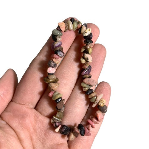 Kindred Crystal Collective — Rhodonite Chip Bracelet (Pack of 5), five mixed pink and dark stone chip bracelets arranged around a white crystal cluster on a white background.