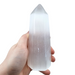 Selenite crystal obelisk tower close-up showing luminous moonlike glow and natural striations, for peace and mental calm