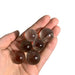Kindred Crystal Collective — Smoky Quartz Mini Sphere Pack, six polished translucent smoky brown quartz mini spheres, size reference held in open palm