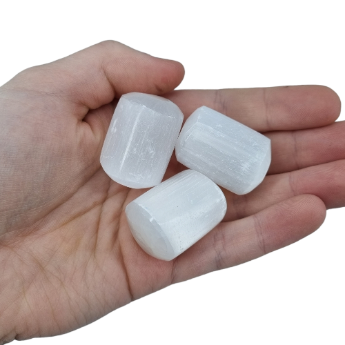 Kindred Crystal Collective — Selenite Tumbled 3–3.5cm, three large translucent white selenite tumbled stones with striation lines held in open palm