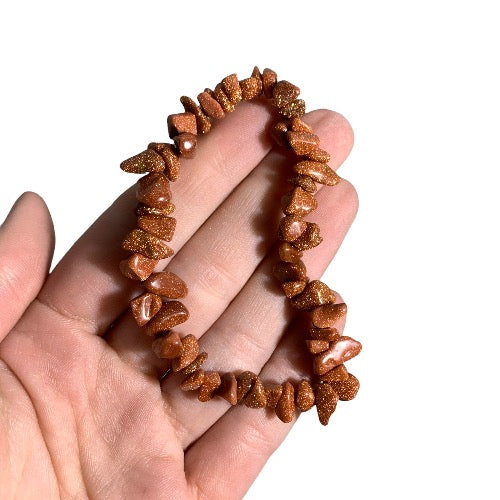 Kindred Crystal Collective — Goldstone Chip Bracelet (Pack of 5), copper-brown sparkling chip bracelets arranged around a white crystal cluster.